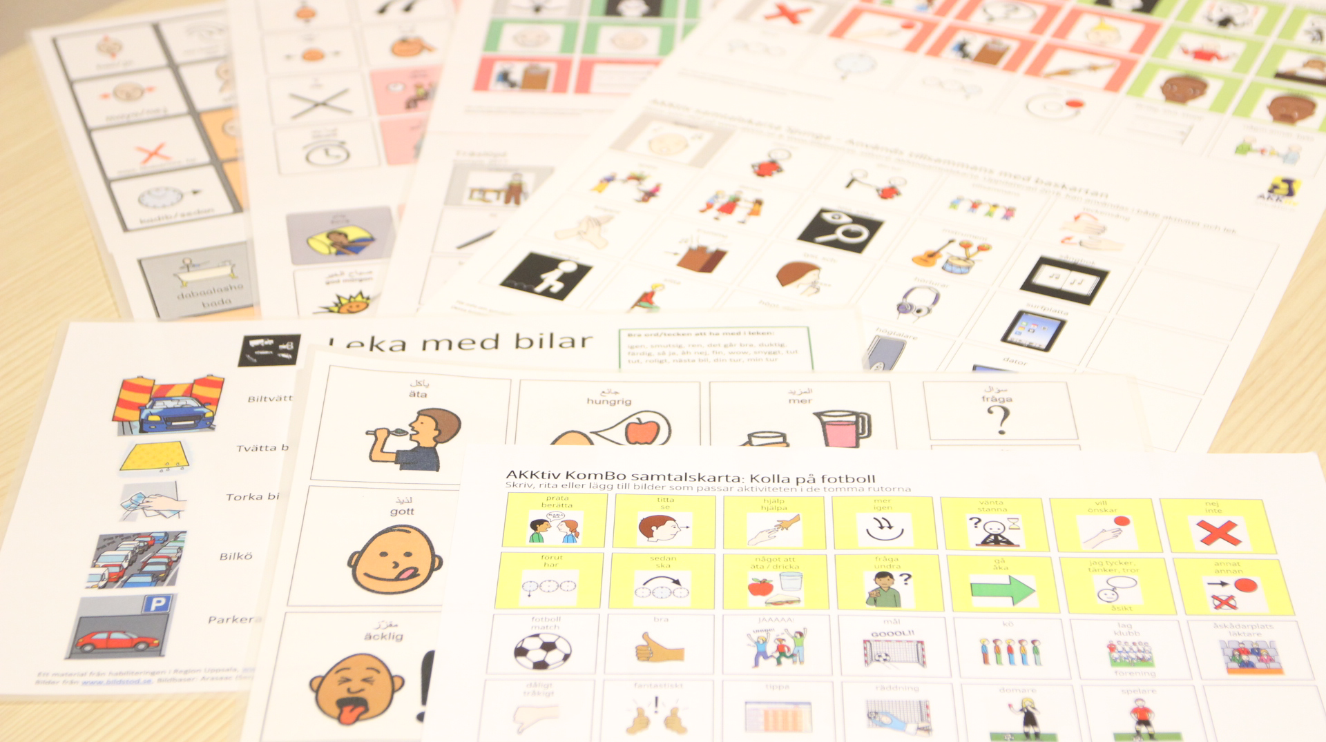 Flera ark med bilder och text utspridda över ett bord