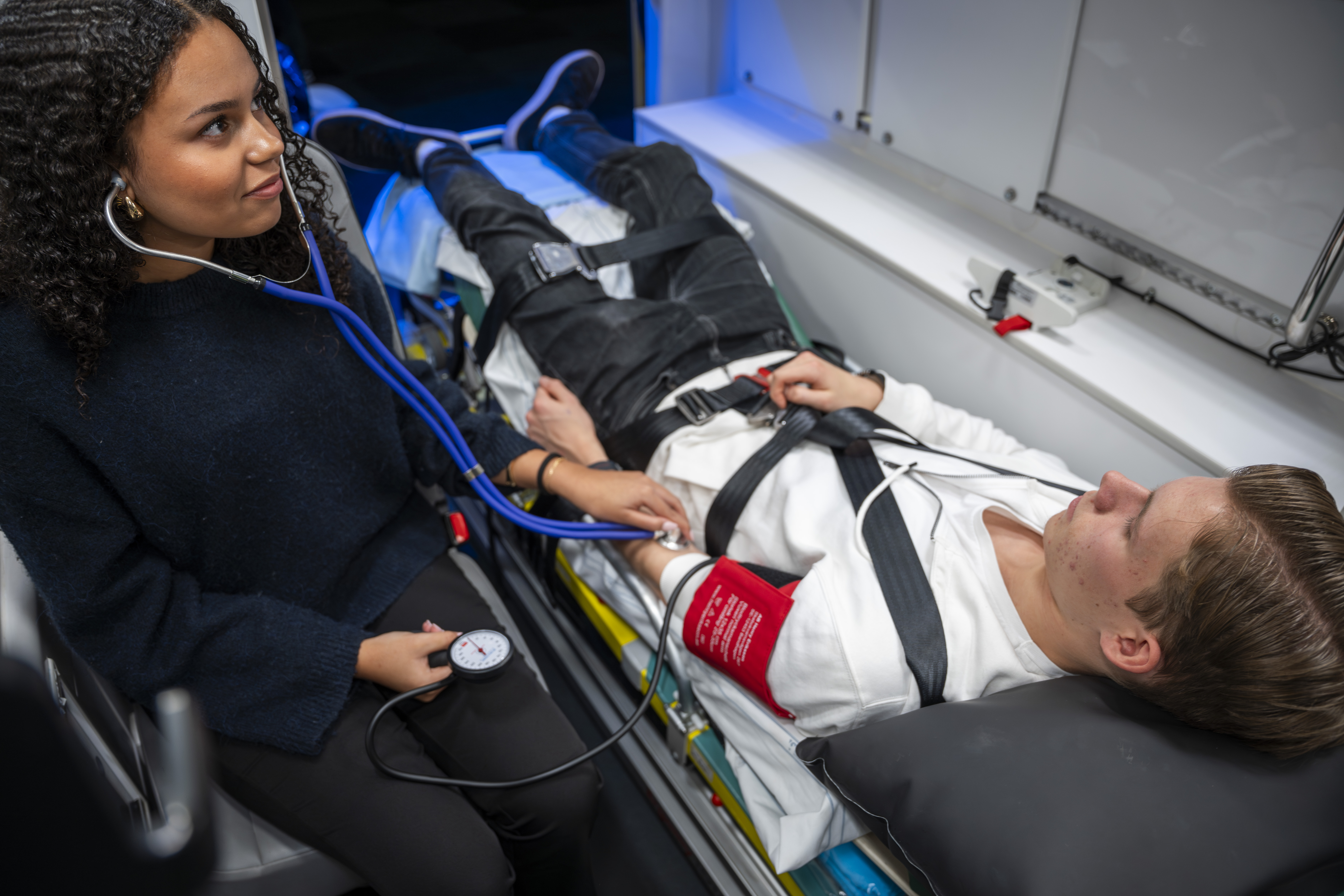 Två ungdomar testar utrustning i ambulans