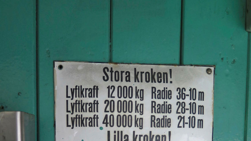 Skylt med viktangivelser och radie för stora och lilla kroken. Varningsskylt: När kranen är i drift skall 1. Kranjobben ställas in på 36 meters radie och parallellt med kranbanan. 2. Bromsarna dragas åt till sväng och jibb-maskinerna. 3. Rälsklammerna låsas fast. 4. Huvud ström brytaren à portalen brytes.