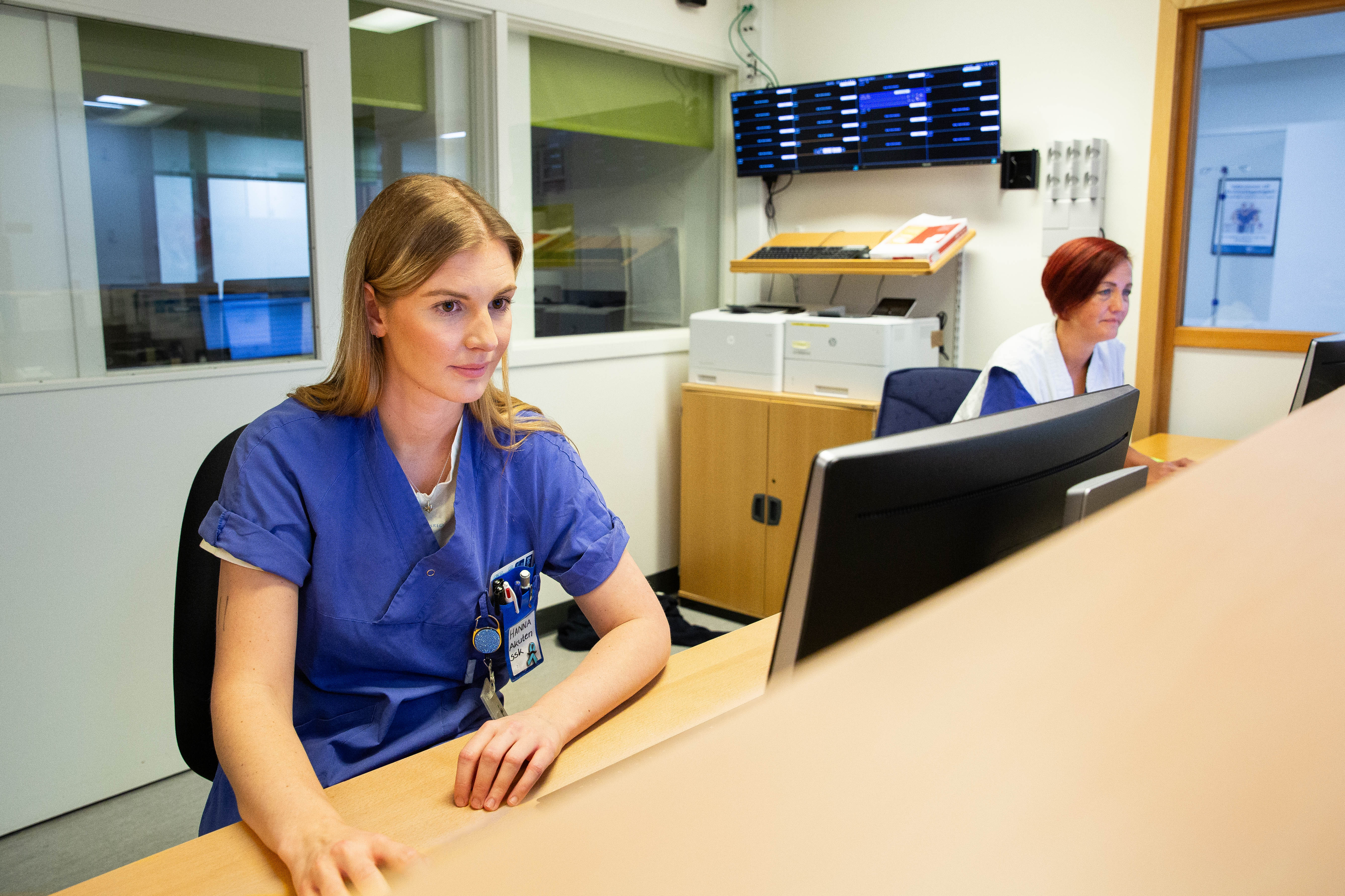 Vårdpersonal arbetar framför dator. 